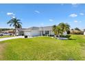 Inviting single-story home with lush green lawn, palms and clean white facade at 12147 Se 173Rd Pl, Summerfield, FL 34491
