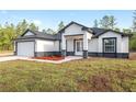 Newly built one story home with front facing 2 car garage, stylish accents, and small flower bed at 12689 Sw 81St St, Dunnellon, FL 34432