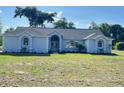 Well-maintained single-story home with a lush green lawn, showcasing its inviting curb appeal and serene setting at 13430 Ne 30Th Ct, Anthony, FL 32617