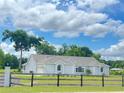 Single-story home featuring a sprawling lawn, classic windows and a split-rail fence at 13430 Ne 30Th Ct, Anthony, FL 32617