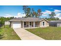 Charming one-story home featuring a covered porch, single car garage, a long driveway, and a front lawn at 15640 Sw 48 Ave, Ocala, FL 34473