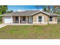 Charming one-story home featuring a covered porch, single car garage, and a well-maintained front lawn at 15640 Sw 48 Ave, Ocala, FL 34473