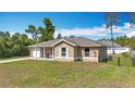 Charming one-story home featuring a covered porch, single car garage, and a well-maintained front lawn at 15640 Sw 48 Ave, Ocala, FL 34473