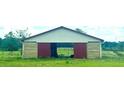 Rustic barn with a red roof, sliding red doors, and natural wood siding at 16850 Se 19Th Ct, Summerfield, FL 34491