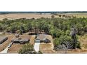 Expansive aerial view of a single-Gathering home with green surroundings and a view of distant fields at 171 Oak Cir, Ocala, FL 34472