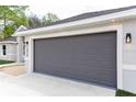 Close-up of the gray two-car garage door with modern lighting fixtures at 174 Sequioa Trl, Ocklawaha, FL 32179