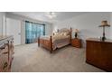 Cozy bedroom with plush carpet, a ceiling fan, and ample natural light at 21425 Sw Plantation St, Dunnellon, FL 34431