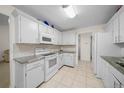 Bright kitchen with white cabinets, granite countertops, and stainless steel appliances at 21425 Sw Plantation St, Dunnellon, FL 34431