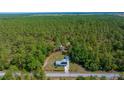 An aerial view of the property and neighborhood, surrounded by verdant green trees at 23737 Nw Mallard Ave, Dunnellon, FL 34431