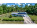 Charming single-story home featuring solar panels, a covered carport, and a well-manicured front yard at 23737 Nw Mallard Ave, Dunnellon, FL 34431