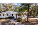 Side view of a white home featuring a well-manicured lawn and walkway leading to the entrance at 3250 Sw 46Th Ave, Ocala, FL 34474