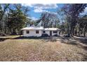 A single-story home is nestled among mature trees, offering a serene and private setting at 3250 Sw 46Th Ave, Ocala, FL 34474