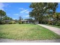 Inviting single-story home with lush green lawn, mature trees and long driveway at 511 Se 29Th Ter, Ocala, FL 34471