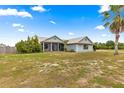 Well-maintained single-story home with a metal roof, a screened porch and a large front yard at 6045 Se 99Th Pl, Belleview, FL 34420