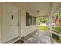 Inviting front porch with vintage details and an American flag, perfect for enjoying the outdoors at 608 Se 31St Ter, Ocala, FL 34471