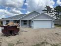 New construction home with a gray exterior, attached two-car garage, and simple landscaping at 7781 Sw 180Th Cir, Dunnellon, FL 34432