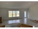The spacious living room features wood-look tile flooring, a large window, and a glass-paned exterior door at 7781 Sw 180Th Cir, Dunnellon, FL 34432