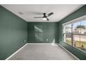 Neutral bedroom with carpet flooring, ceiling fan, and a large window at 8617 Triumph Cir, Wildwood, FL 34785