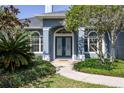 Beautiful home entrance with double doors, decorative glass, and lush landscaping enhancing curb appeal at 8950 Se 17Th Ct, Ocala, FL 34480