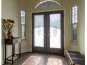 Elegant foyer showcasing decorative double doors, stylish tile flooring, and transom windows for natural light at 8950 Se 17Th Ct, Ocala, FL 34480