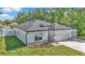 Well-manicured lawn highlights this single-story home with a modern design and attached two-car garage at 9405 Se 159Th Ln, Summerfield, FL 34491