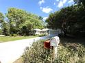 Exterior shot of the home with beautiful landscaping and a blue sky backdrop at 9711 Sw 196Th Cir, Dunnellon, FL 34432