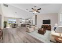 Spacious living room featuring hardwood floors, neutral paint, and an open floor plan to the kitchen and dining area at 10426 Sw 133Rd Ave, Dunnellon, FL 34434