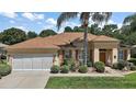 Well-maintained home featuring a two-car garage, lush landscaping, and inviting curb appeal at 12165 Se 91St Ave, Summerfield, FL 34491
