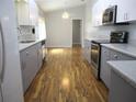 Well-lit kitchen features modern gray and white cabinets, stainless steel appliances, and wood-look floors at 13816 Sw 112Th Ter, Dunnellon, FL 34432