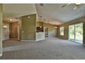 Large living room with neutral colored walls, carpeted floors, and a sliding glass door at 1551 Sw Willow Road Ext, Dunnellon, FL 34431