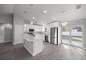 Modern kitchen with stainless steel appliances, white cabinets, an island, and sliding glass doors at 20812 Sw Cardinal Ave, Dunnellon, FL 34431