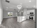 Stylish open-concept kitchen with stainless appliances, white cabinets, and adjacent living area at 20812 Sw Cardinal Ave, Dunnellon, FL 34431