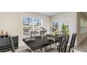 Bright dining room with a large table, seating for six and a view of the outdoor living space at 357 Hickory Course Trl, Ocala, FL 34472