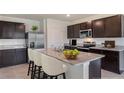 Modern kitchen with stainless steel appliances, dark cabinets and a large granite island with bar stool seating at 357 Hickory Course Trl, Ocala, FL 34472