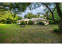 Spacious front yard featuring lush grass and mature trees at 3579 Sw Shorewood Dr, Dunnellon, FL 34431