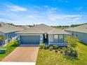 An exterior view of the home in a suburban neighborhood with well-maintained landscaping and inviting curb appeal at 4411 Nw 53Rd Ct, Ocala, FL 34482