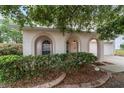 Arched front porch entry with trimmed hedges and low maintenance landscape beds at 4624 Se 32Nd Pl, Ocala, FL 34480