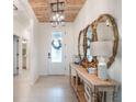 Bright foyer with tile flooring, wooden ceiling, elegant console table, and decorative mirrors at 4743 Nw 11Th Ct, Ocala, FL 34475