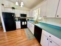 Efficient kitchen with white cabinets, black appliances, and a window over the sink at 6070 Sw 98Th Loop, Ocala, FL 34476