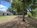 Expansive backyard with mature trees and a patio, perfect for outdoor activities at 6306 Pecan Crse, Ocala, FL 34472