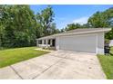 Well-maintained single-Gathering home featuring a spacious two-car garage and a green lawn at 6306 Pecan Crse, Ocala, FL 34472