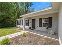 Inviting front porch with a white rocking chair, dark shutters, and a 'Beware of Dog' sign at 6306 Pecan Crse, Ocala, FL 34472