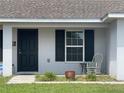 Close-up of the front door and window with dark shutters, enhancing curb appeal at 6306 Pecan Crse, Ocala, FL 34472
