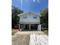 Stilt home showcasing a front entrance with a spacious carport and ladder in view at 6498 Se 167Th Ct, Ocklawaha, FL 32179