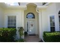 Inviting front entrance with white door, sidelights, arched window, and manicured shrubbery at 6836 Sw 112Th St, Ocala, FL 34476