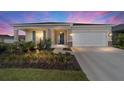 Lovely home featuring a well-manicured lawn, beautiful landscaping, and an attached two-car garage, set against a dramatic sky at 7706 Sw 89Th Ct, Ocala, FL 34481