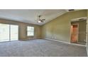 Bright living room with vaulted ceiling, neutral walls, plush carpeting, and sliding glass door to the exterior at 8301 Sw 128Th Loop, Ocala, FL 34473