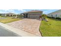 Well-maintained single-story home featuring a paved driveway, manicured lawn, and a two-car garage at 8998 Sw 75Th Loop, Ocala, FL 34481