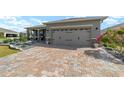 Charming home with a paved driveway leading to a two-car garage, complemented by colorful landscaping at 8998 Sw 75Th Loop, Ocala, FL 34481