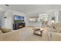 Bright open-concept living area with a modern fireplace, neutral decor, and seamless flow to the kitchen at 9565 Sw 194Th Cir, Dunnellon, FL 34432